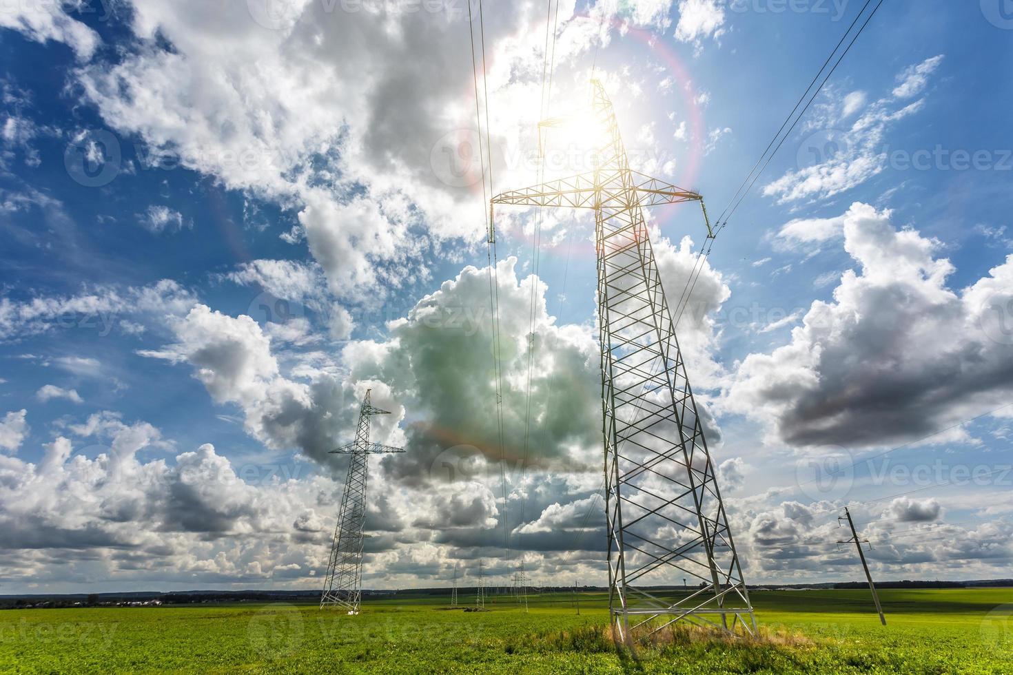 Silhouette of the high voltage electric pylon towers on the background of beautiful clouds photo