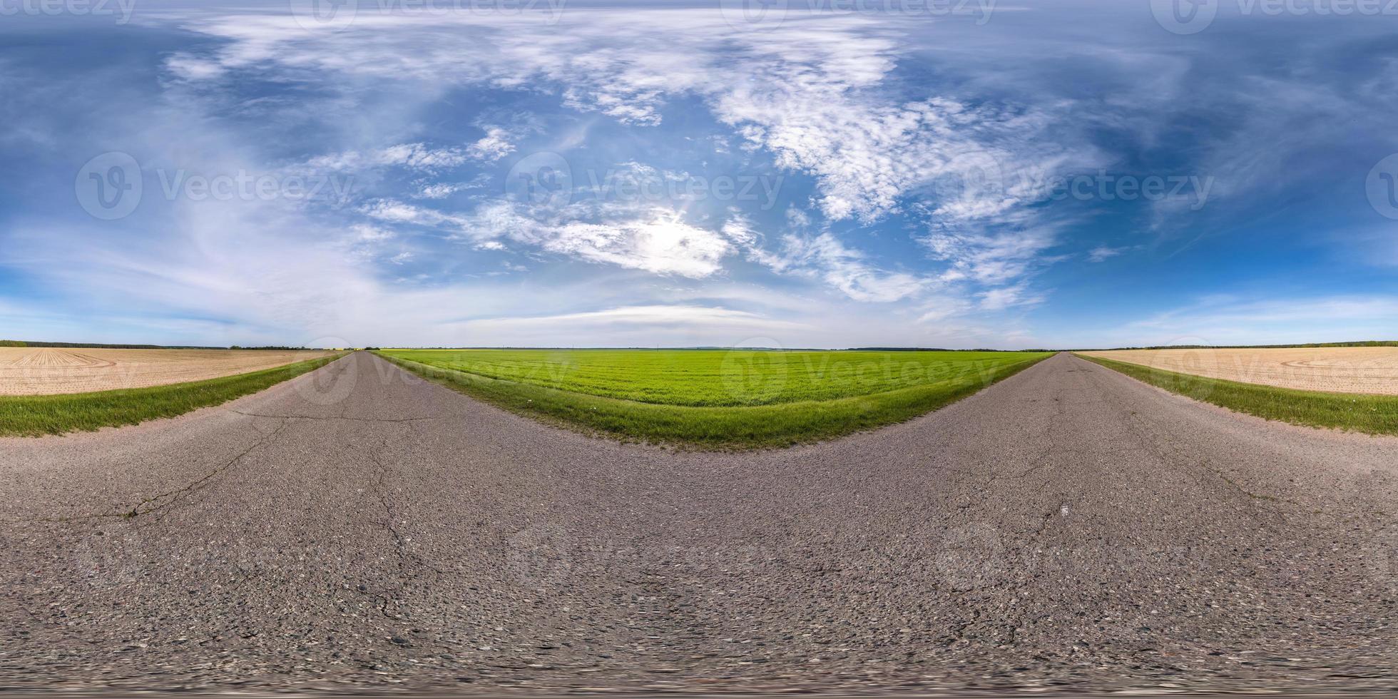 Full spherical seamless panorama 360 degrees angle view on no traffic asphalt road among fields with cloudy sky in equirectangular projection, VR AR content photo