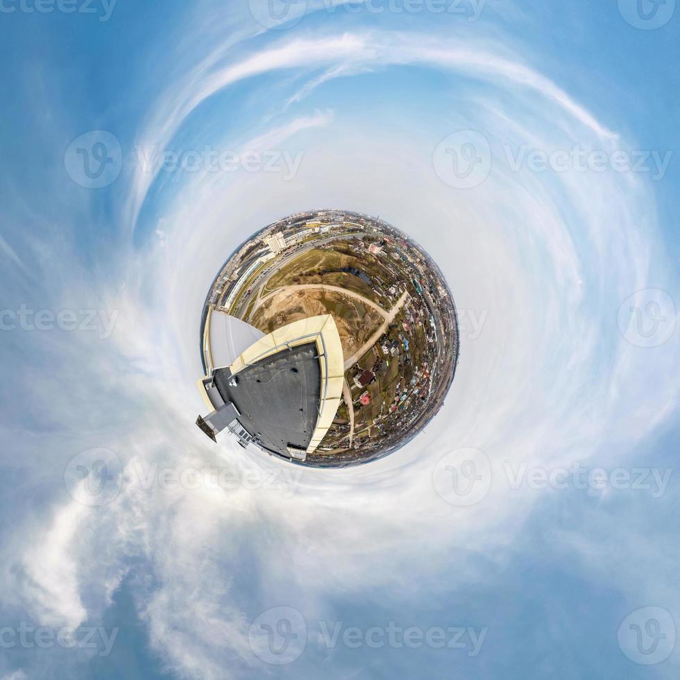 Little tiny planet from roof of multi-storey building with aerial view of construction residential quarter, white clouds and soft blue sky of amusement park. 360 viewing angel. Planet Earth. photo