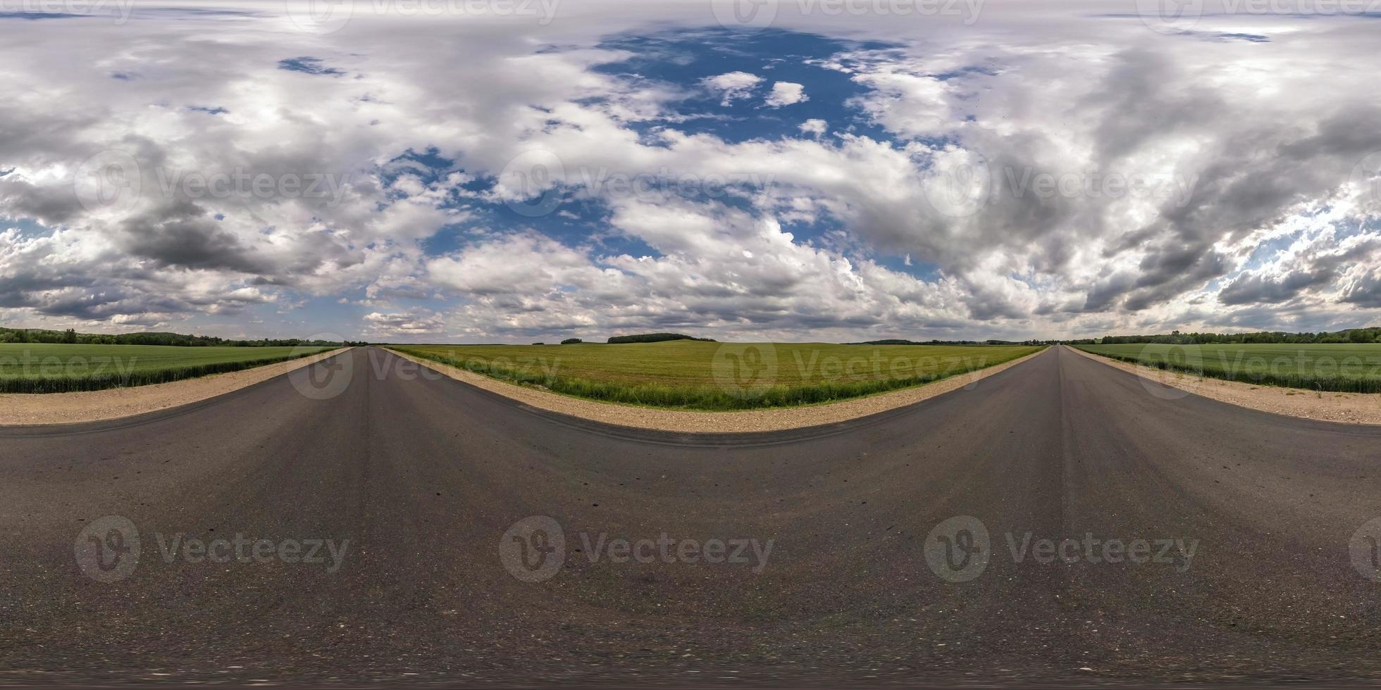 Full spherical seamless hdri panorama 360 degrees angle view on no traffic asphalt road among fields with cloudy sky in equirectangular projection, VR AR content photo