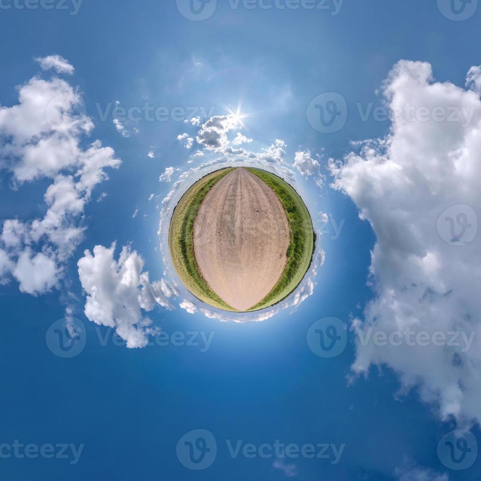 tiny planet in blue sky with sun and beautiful clouds. Transformation of spherical panorama 360 degrees. Spherical abstract aerial view. Curvature of space. photo