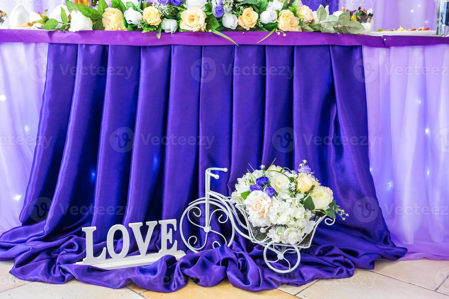 stand for flowers in the form of a bicycle and an inscription love near the festive table photo