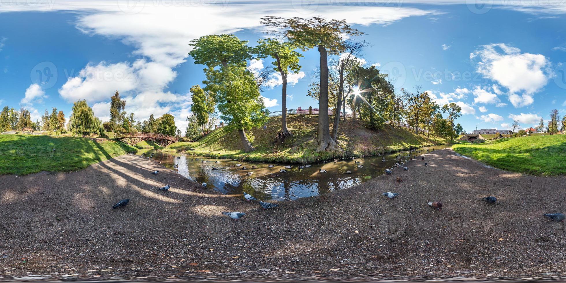 full seamless spherical panorama 360 by 180 degrees angle view on the shore of small river with ducks in city park in summer day in equirectangular projection, AR VR virtual reality content photo