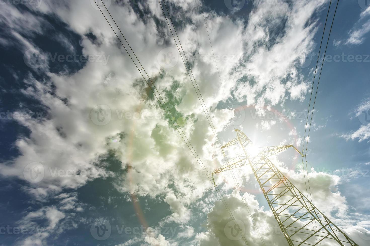 Silhouette of the high voltage electric pylon towers on the background of beautiful clouds photo