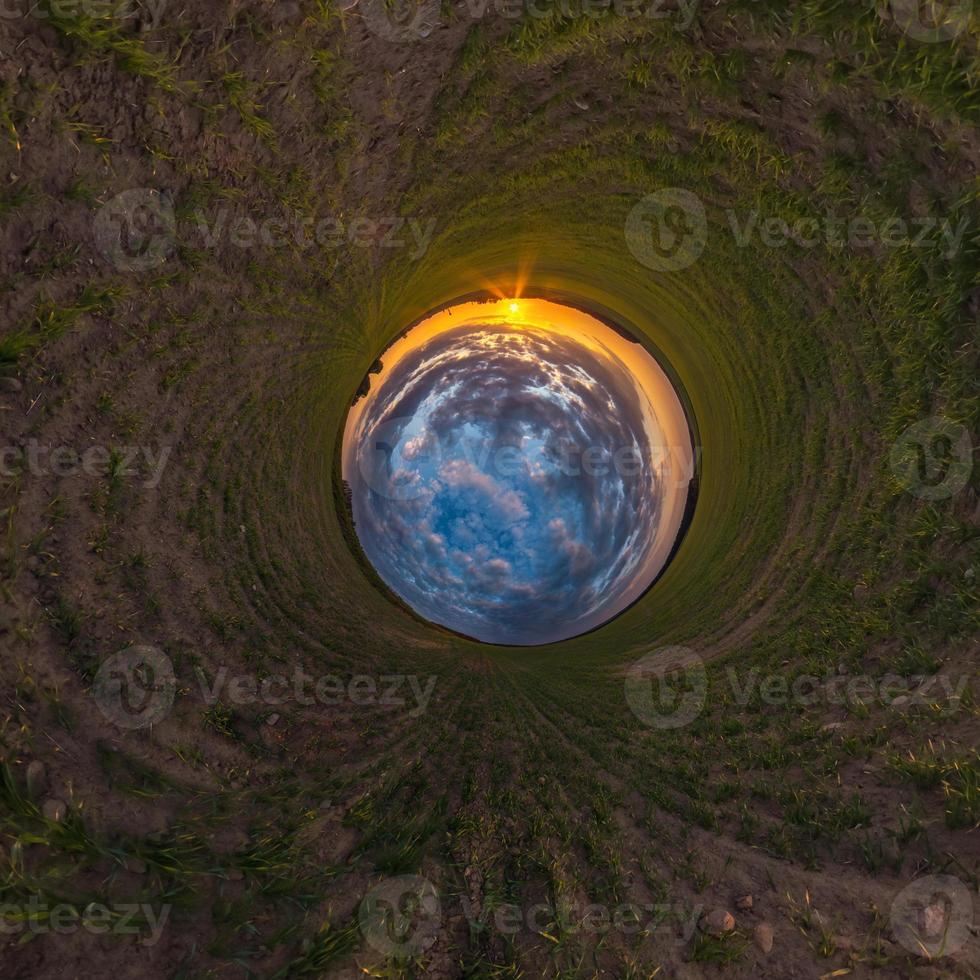 Inversion of little planet transformation of spherical panorama 360 degrees. Spherical abstract aerial view in field with awesome beautiful clouds. Curvature of space. photo