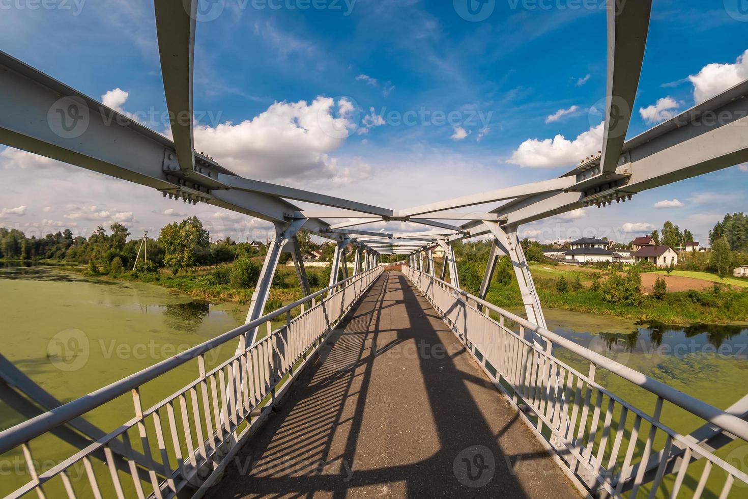 estructura de acero de hierro construcción de puente peatonal a través del río foto