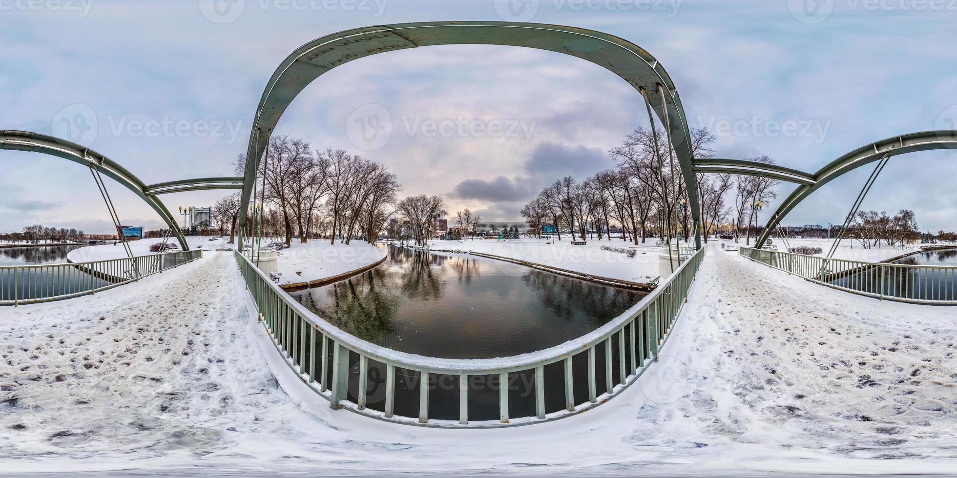 full seamless spherical winter panorama 360 degrees angle view near iron steel frame construction of pedestrian bridge across the river in cite park in equirectangular projection, VR AR content photo