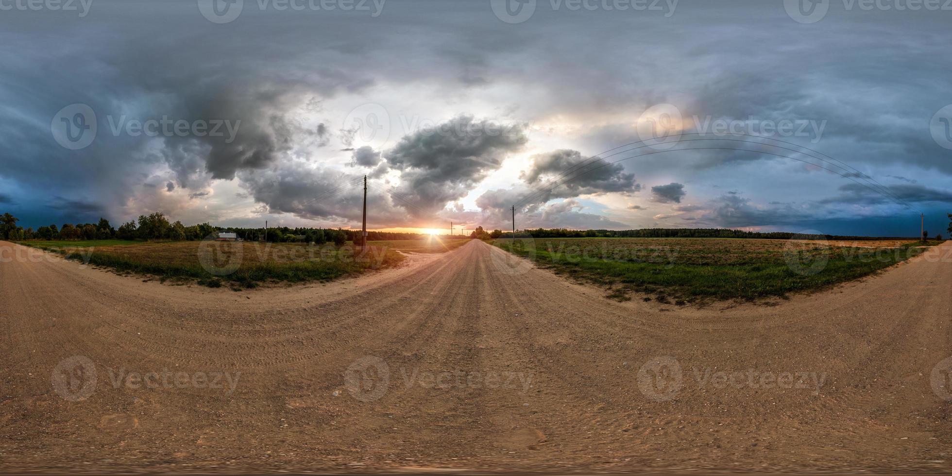 full seamless spherical panorama 360 degrees angle view on gravel road among fields in evening sunset with awesome clouds before the storm in equirectangular projection, VR AR virtual reality content photo