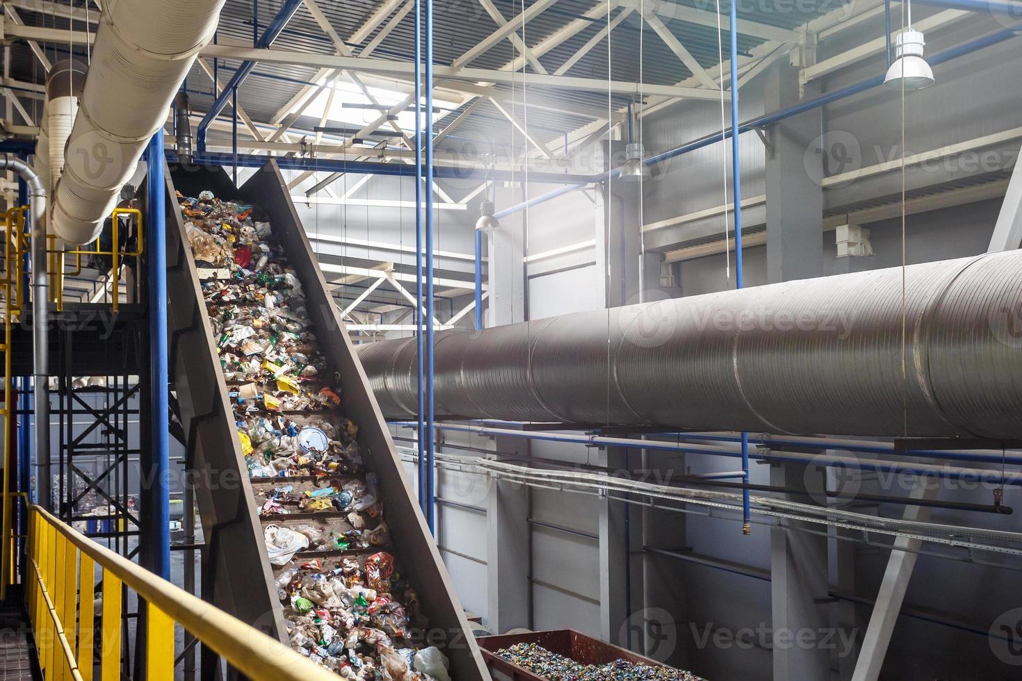 transportador transportador en movimiento en la moderna planta de procesamiento de reciclaje de residuos. separación y clasificación de la recolección de basura. reciclaje y almacenamiento de residuos para su posterior eliminación. foto