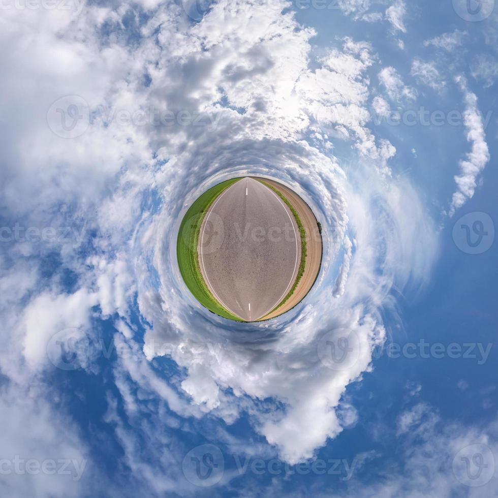 Little planet transformation of spherical panorama 360 degrees. Spherical abstract aerial view in field with awesome beautiful clouds. Curvature of space. photo