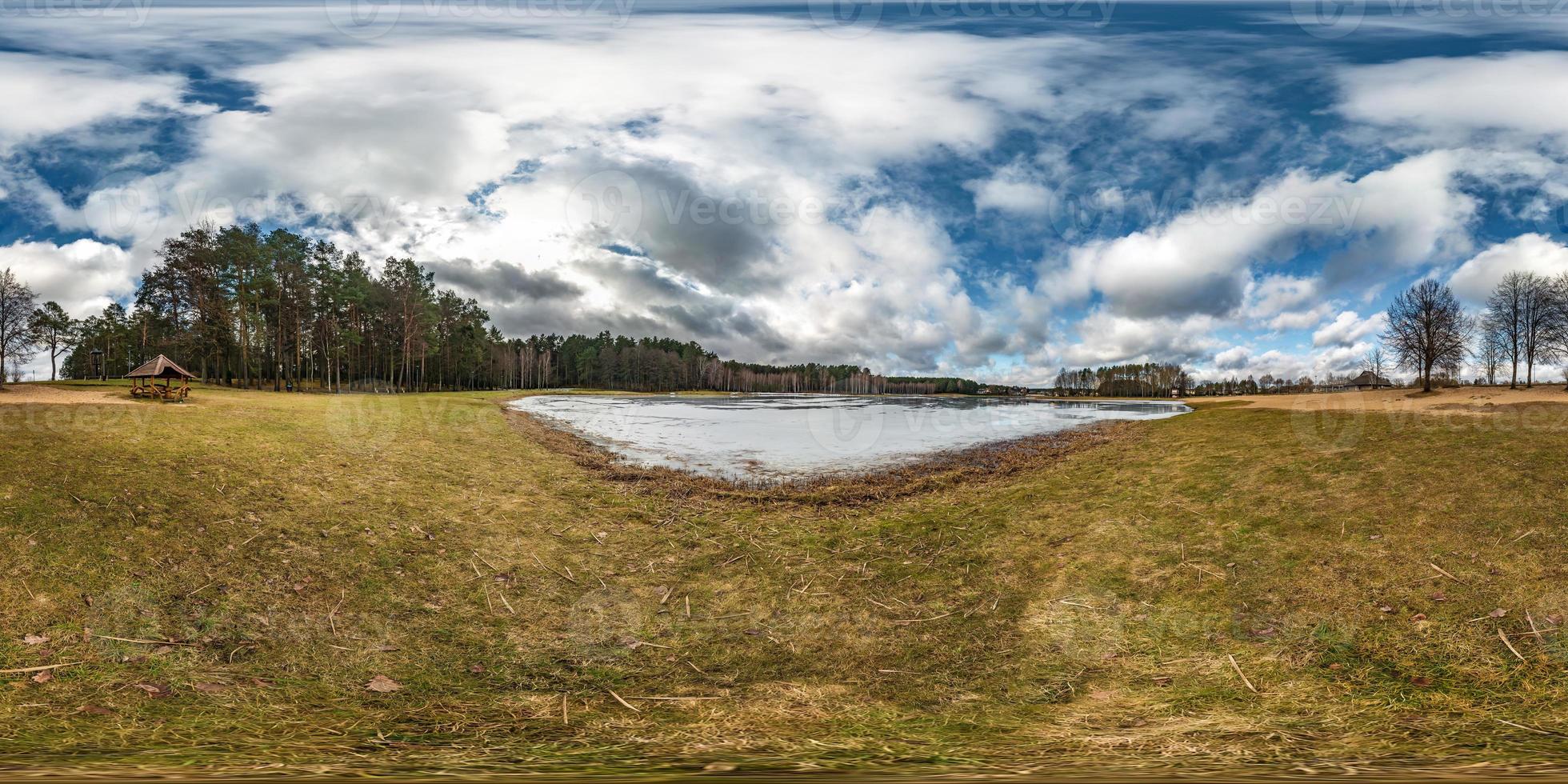 Winter full spherical seamless hdri panorama 360 degrees angle view on road in park with blue sky with beautiful clouds near frozen city lake in equirectangular projection. VR AR content photo