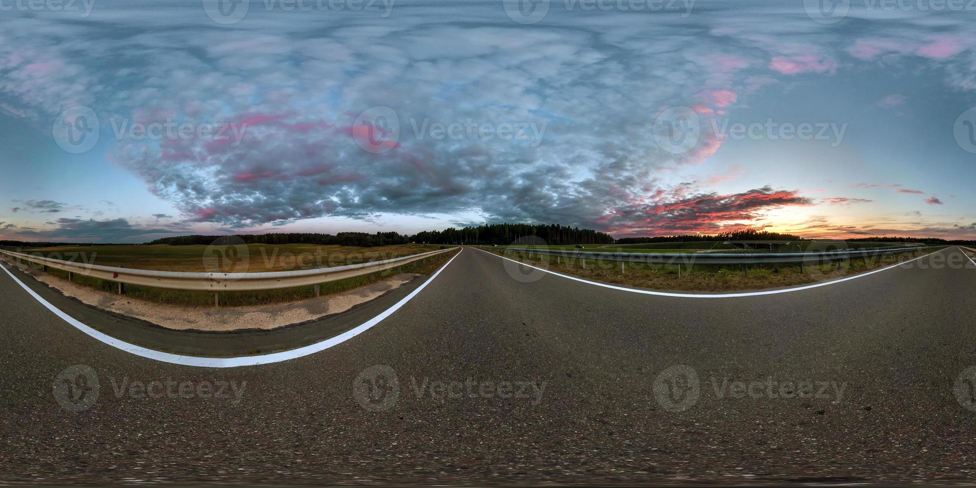 panorama esférico completo sin costuras vista en ángulo de 360 grados en la carretera asfaltada entre los campos en la puesta de sol de la tarde de verano con nubes impresionantes en proyección equirectangular, skybox vr ar contenido de realidad virtual foto