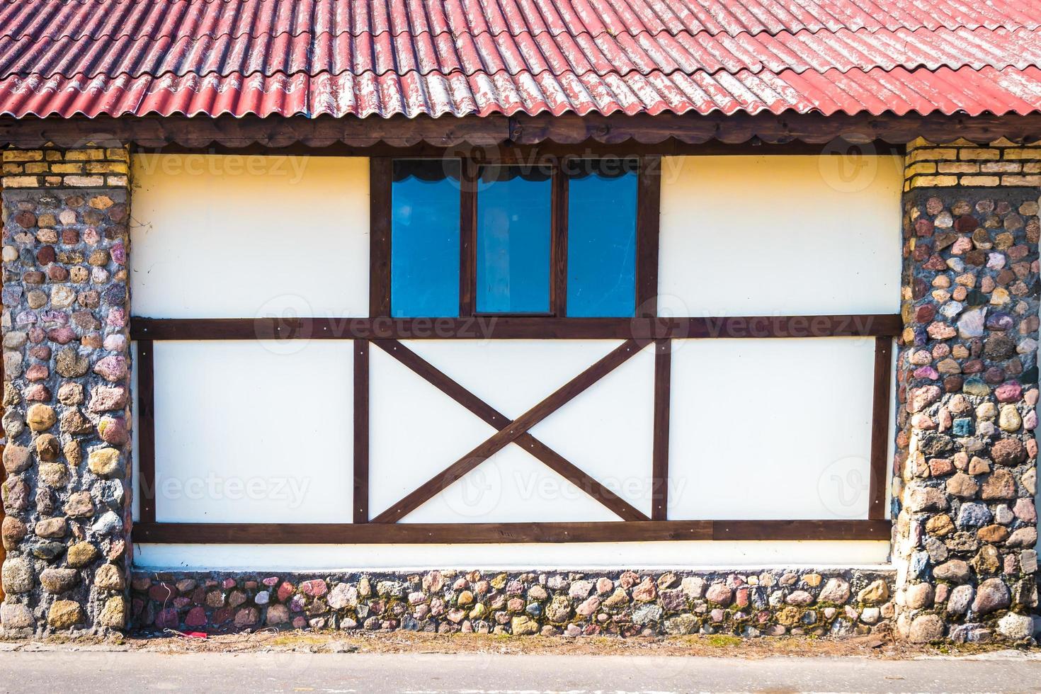 casa tradicional danesa con columnas de piedra estable con techo rojo foto