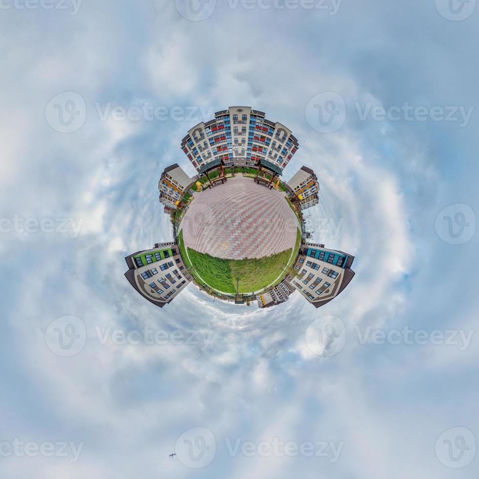 tiny planet in blue sky with clouds in modern multi-storey multi-apartment residential complex of urban development. Transformation of spherical 360 panorama in abstract aerial view. photo