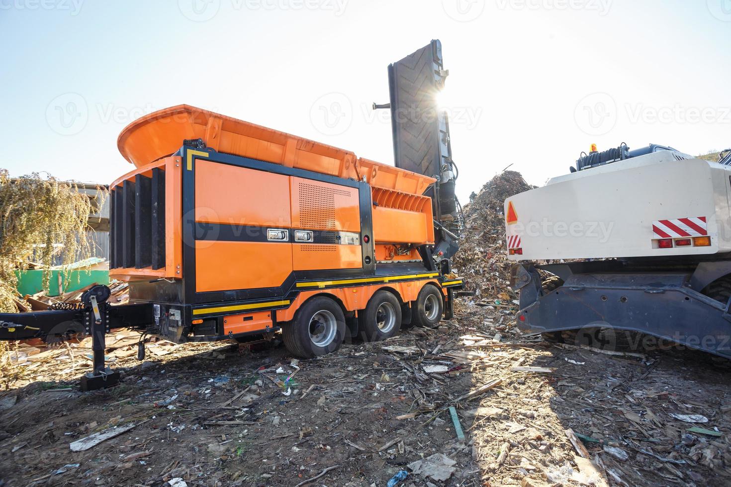 Excavator sorts plastic garbage at waste processing plant. Separate garbage collection. Recycling and storage of waste for further disposal. Business for sorting and processing of waste. photo