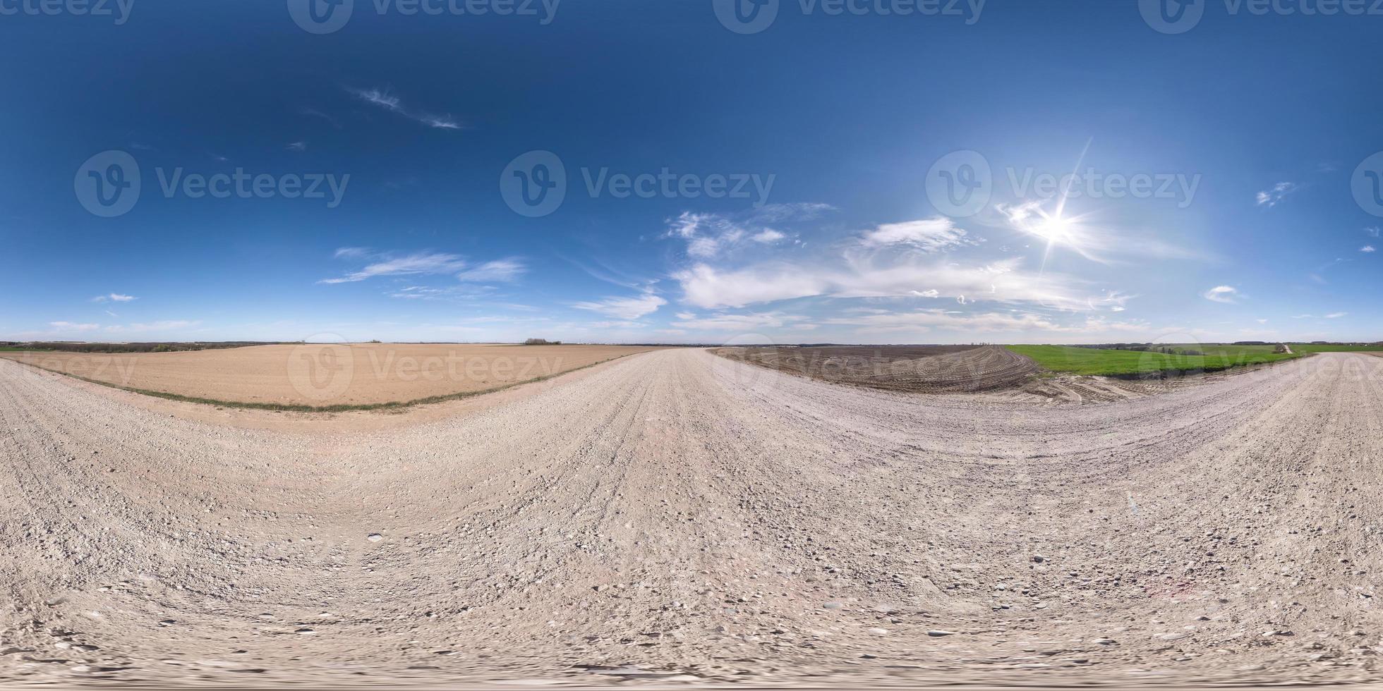 full seamless spherical hdr panorama 360 degrees angle view on white sand gravel road among fields in spring day with awesome clouds in equirectangular projection, ready for VR virtual reality content photo