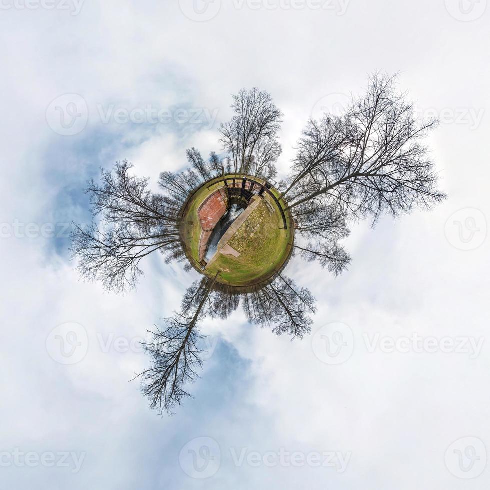 Green little tiny planet with trees near gateway lock sluice construction on river, white clouds and soft blue sky of amusement park. 360 viewing angel. Planet Earth. photo
