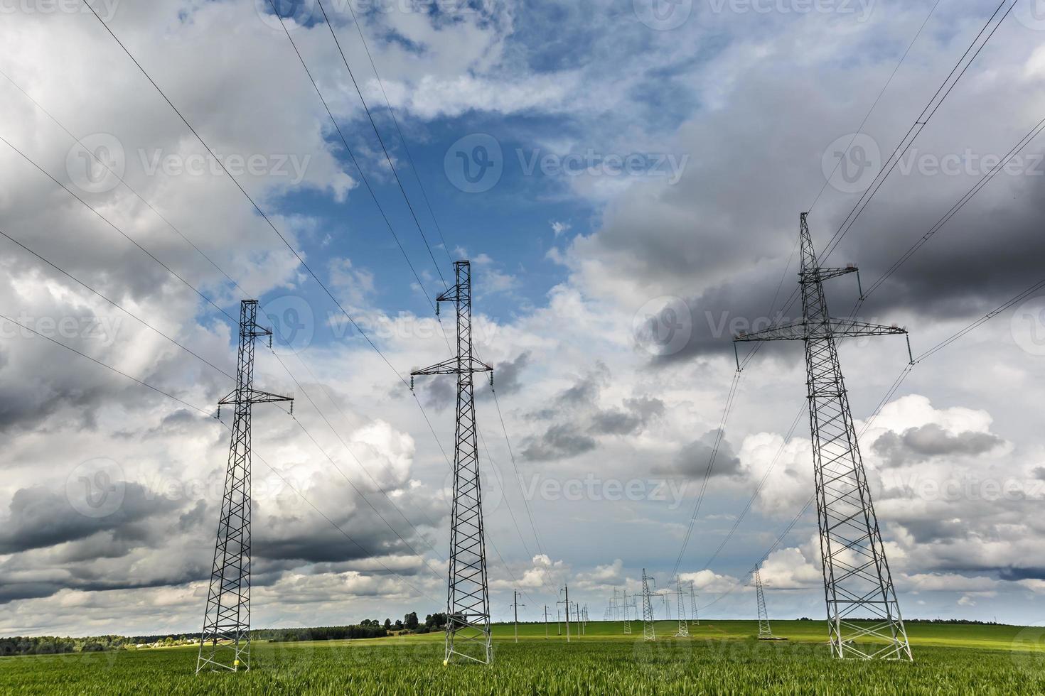 Silhouette of the high voltage electric pylon towers on the background of beautiful clouds photo