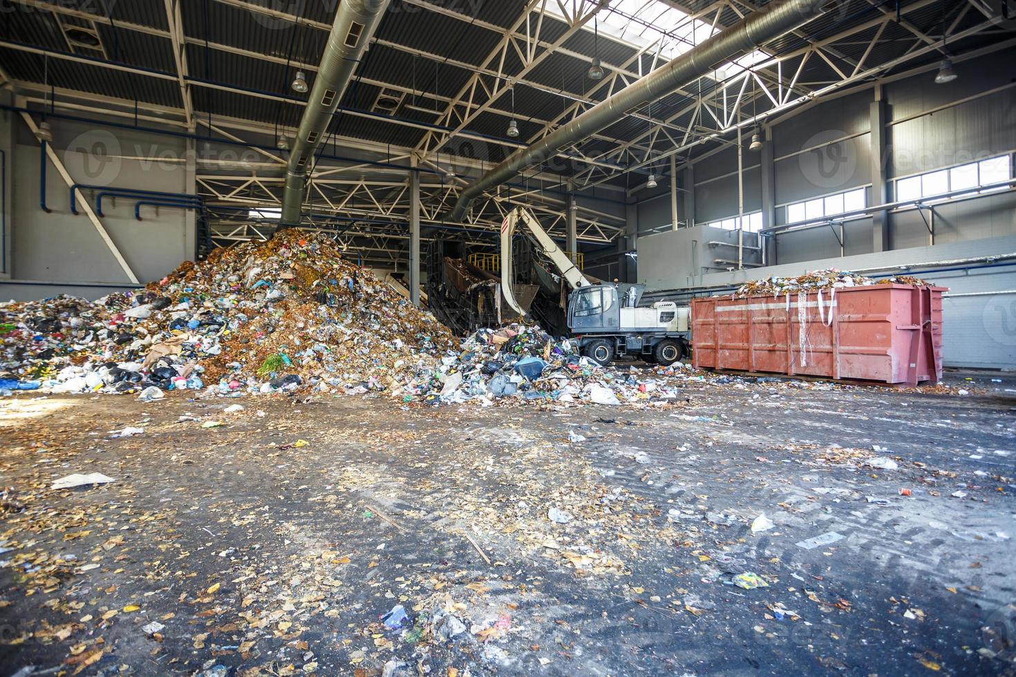 Excavator on primary sorting of garbage at waste processing plant. Separate garbage collection. Recycling and storage of waste for further disposal. Business for sorting and processing of waste. photo