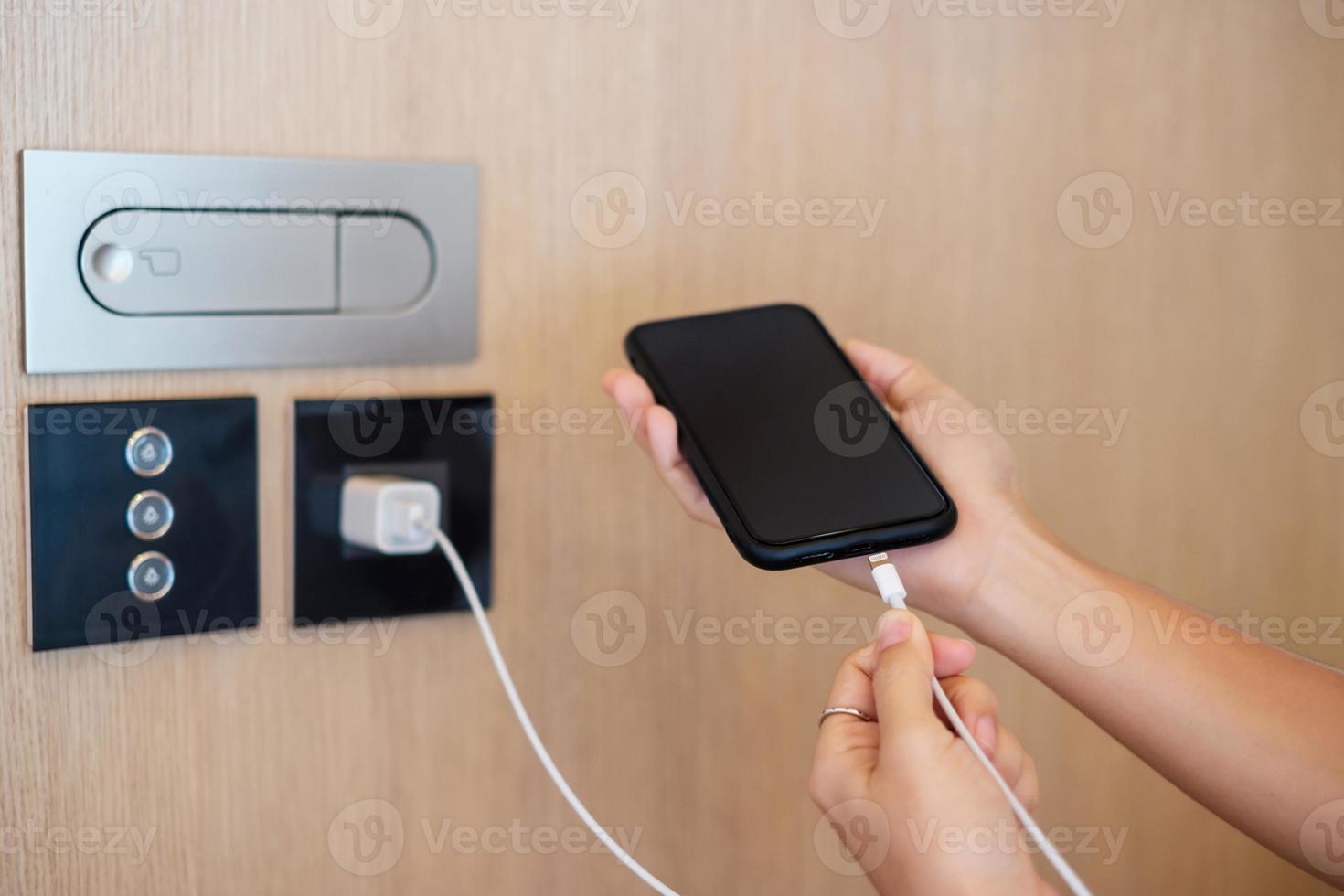 Hand Charging battery on mobile smartphone. Technology, multiple sharing and recharge concepts photo