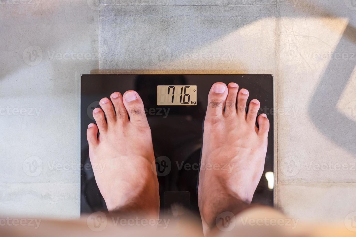 Man stand on the digital weight scale. Diet, weight loss, overweight, obesity and health concept photo