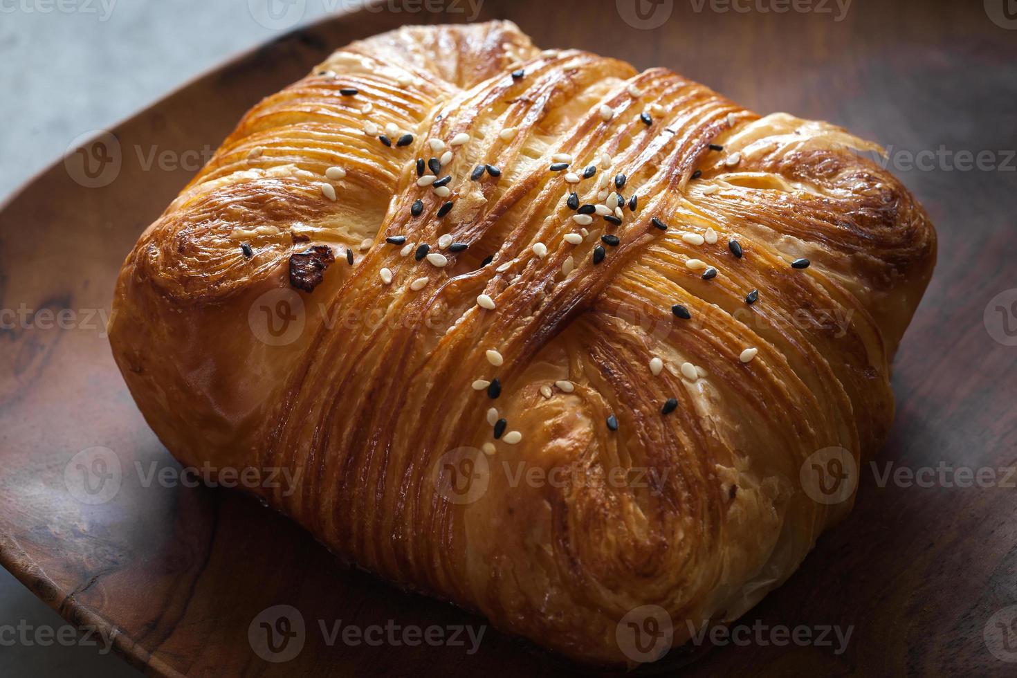 Ham Pastry with sesame sprinkle, look at the texture, buttery fresh on wooden tray, marble table  background. Shoot close up photo