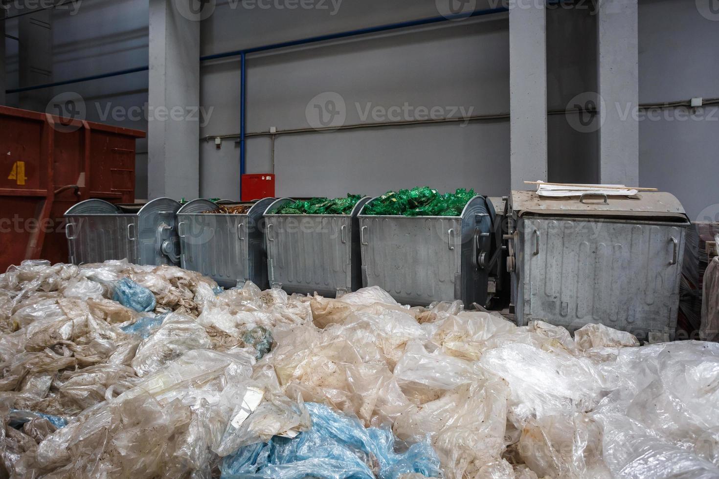 Containers with used bottles and  plastic bales of rubbish at waste treatment processing plant. Recycling separatee and storage of garbage for further disposal, trash sorting. photo