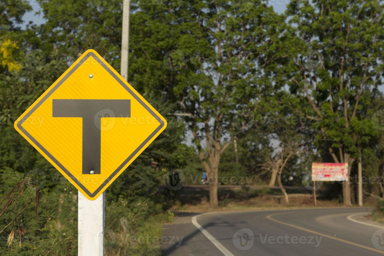 las señales de tráfico tengan cuidado con las carreteras y las intersecciones, conduzca despacio y tenga cuidado con las muchas intersecciones que se encuentran más adelante en la carretera rural y el hermoso cielo azul-blanco por la noche. foto