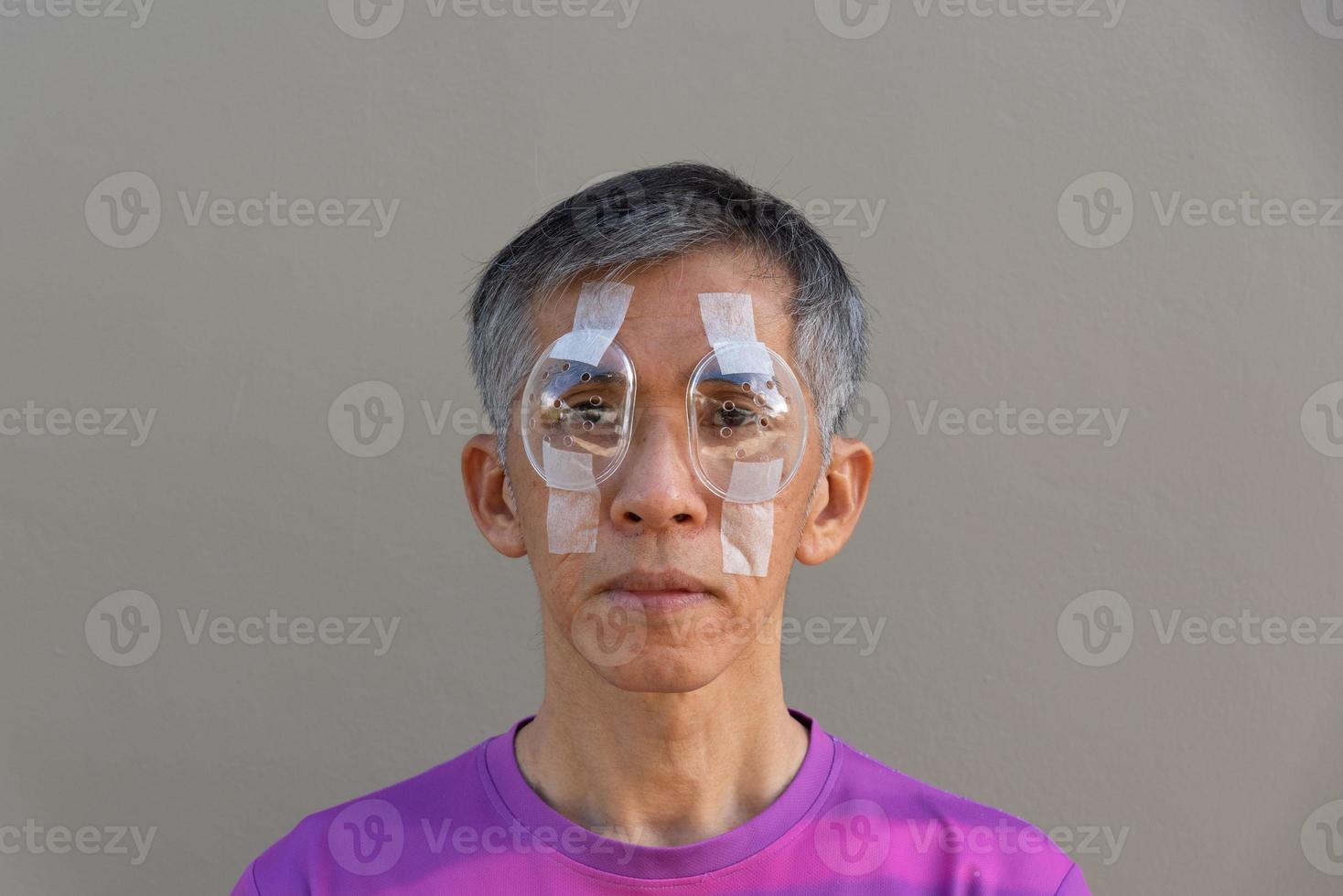 Asian adult male covered both eyes  with protective shields photo