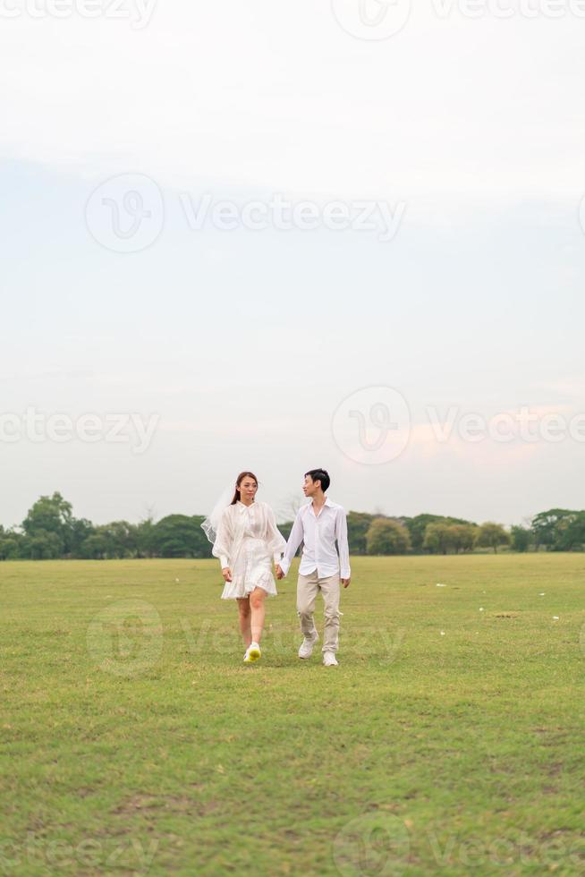 feliz joven pareja asiática vestida de novia y novio foto