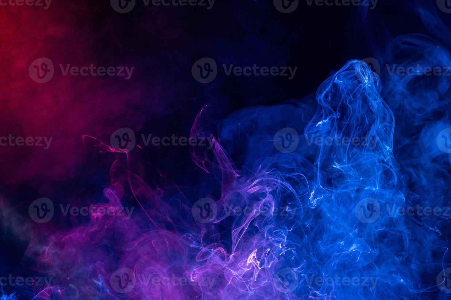 Conceptual image of colorful red and blue color smoke on dark black background. photo
