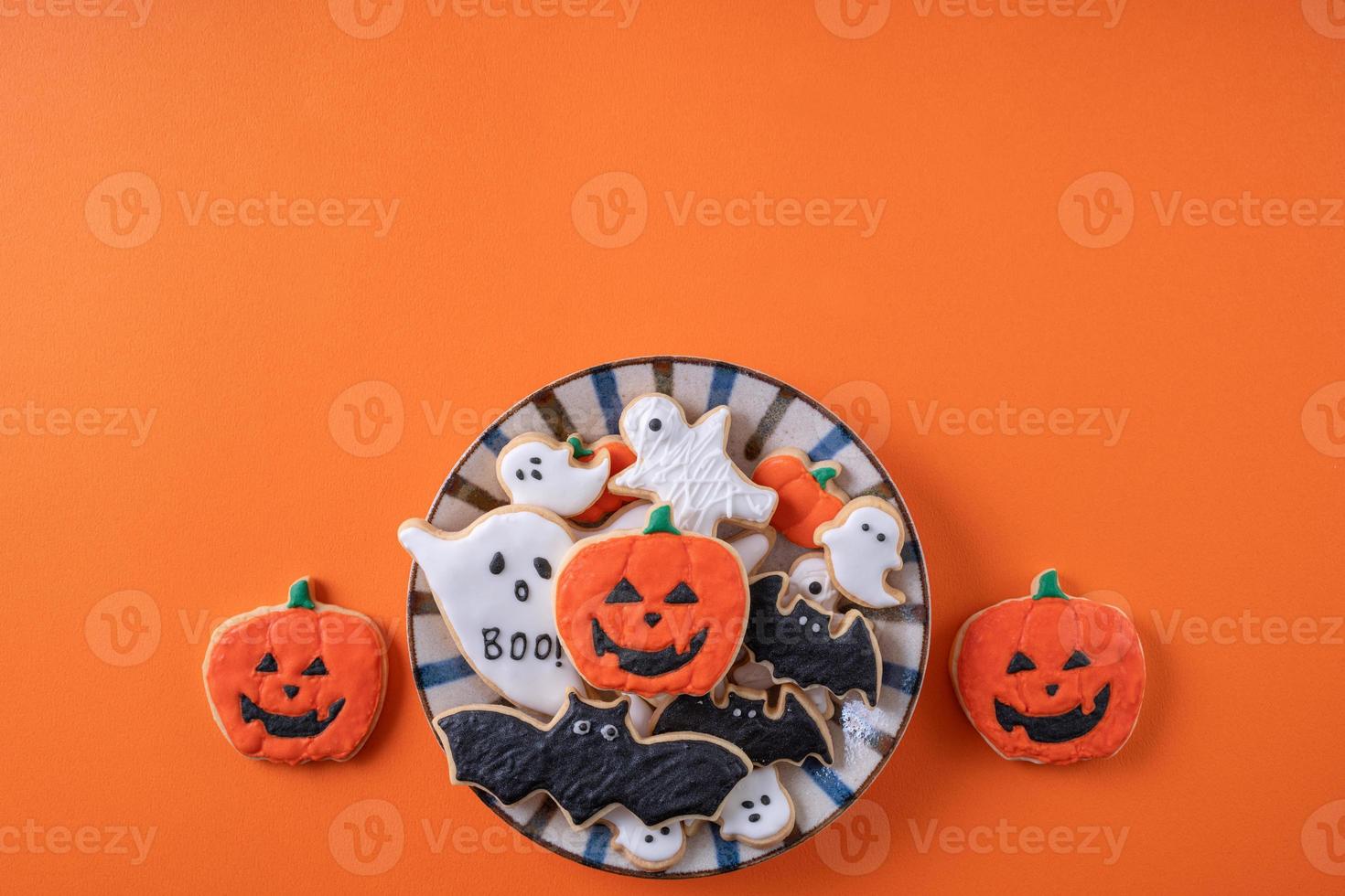 Top view of Halloween festive decorated icing sugar cookies on orange background. photo