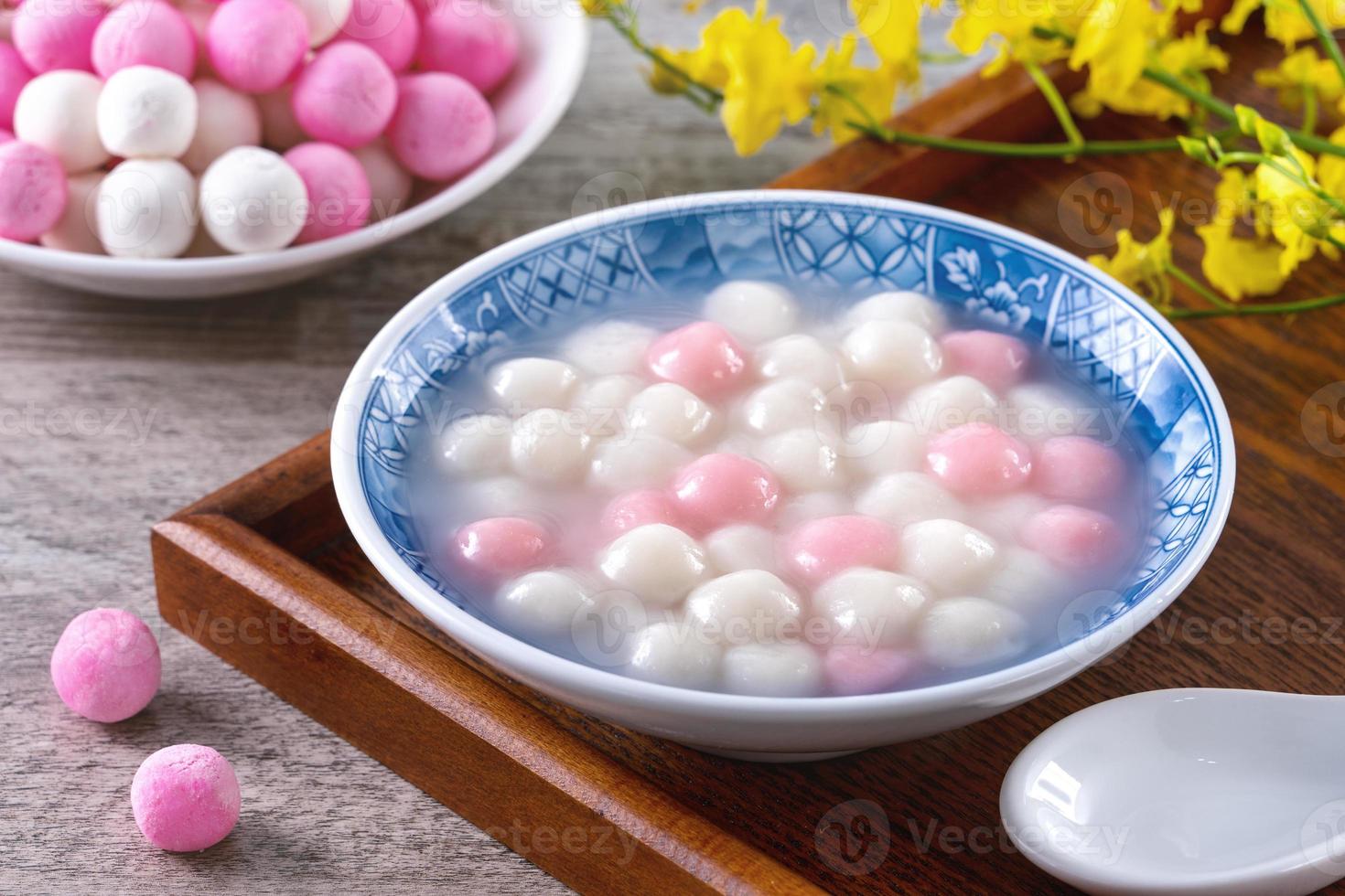 Close up of red and white tangyuan in blue bowl on wooden background for Winter solstice. photo