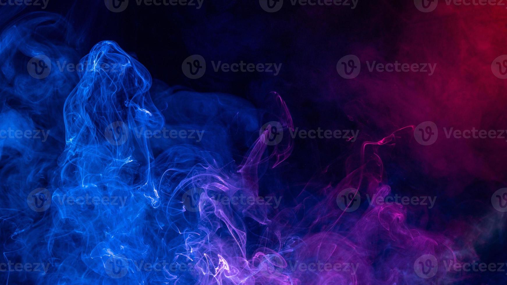 Conceptual image of colorful red and blue color smoke on dark black background. photo
