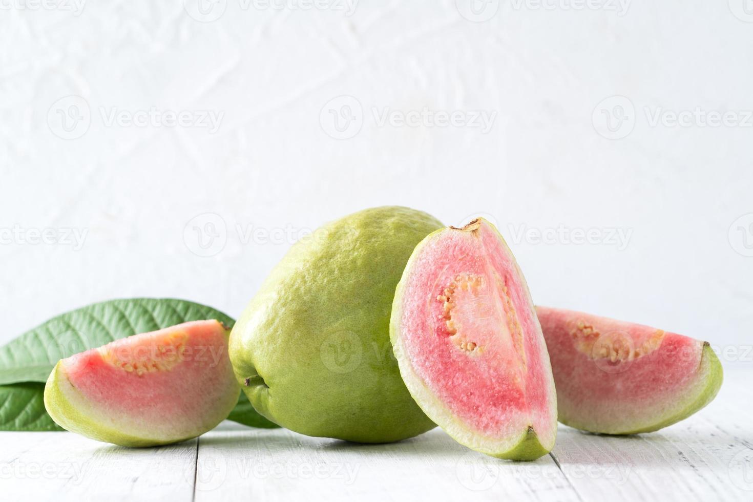 Top view of beautiful red guava with fresh green leaves. photo