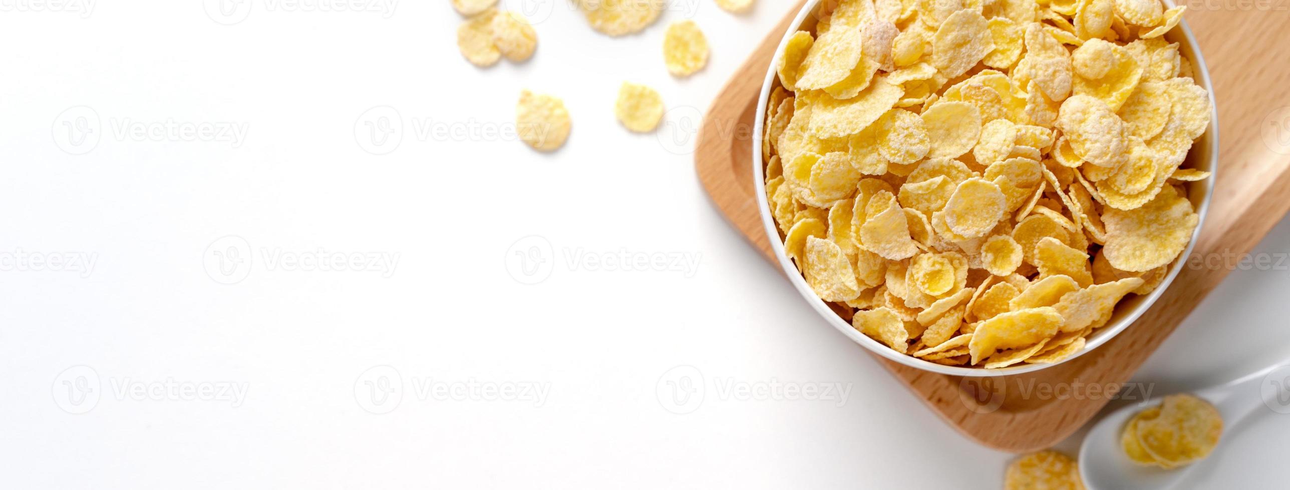 Top view of corn flakes bowl with milk on white background. photo