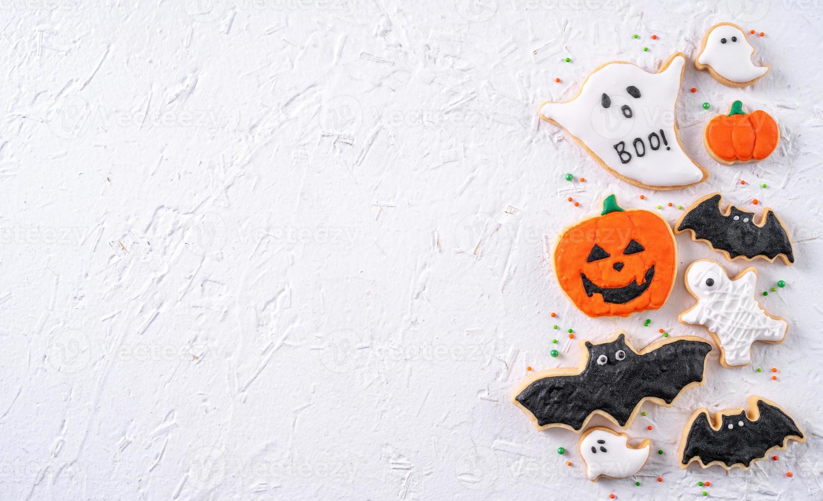 Top view of Halloween festive decorated icing sugar cookies on white background. photo