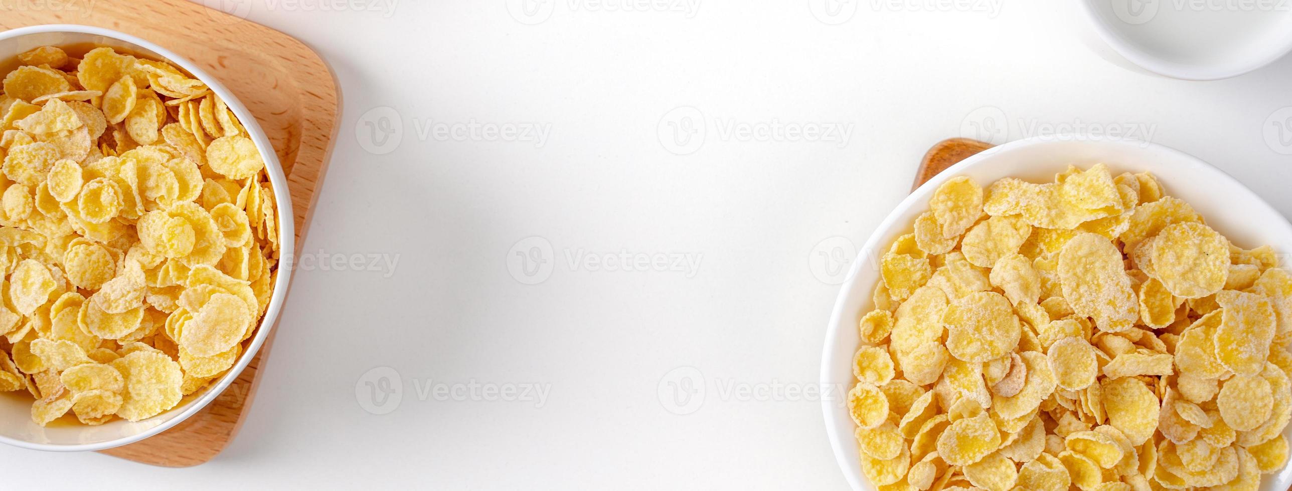 Top view of corn flakes bowl with milk on white background. photo