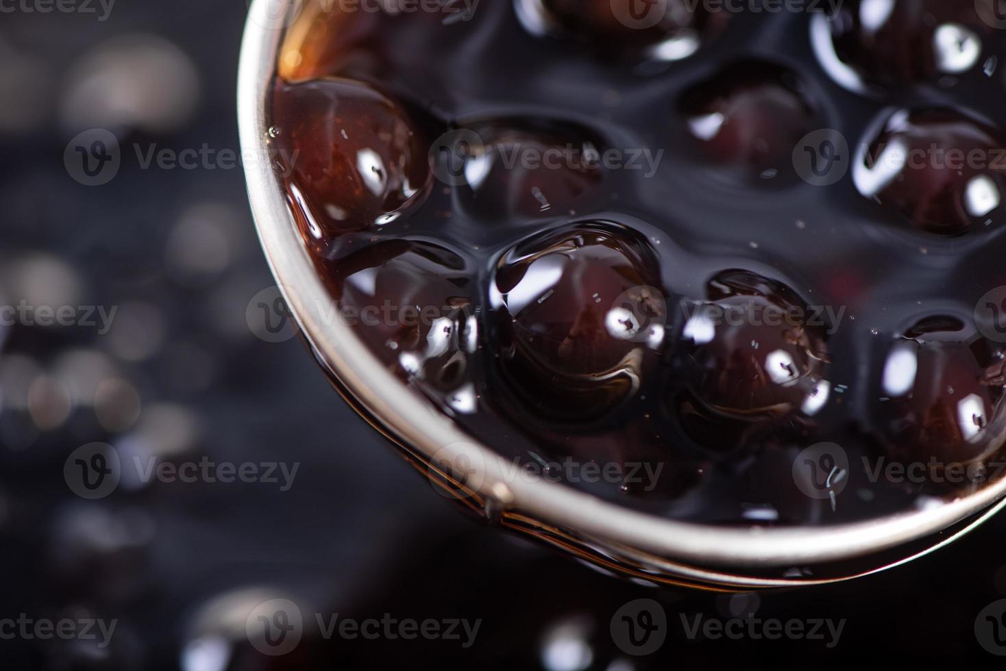 Cooking brown sugar flavored tapioca pearl balls with a scoop. photo