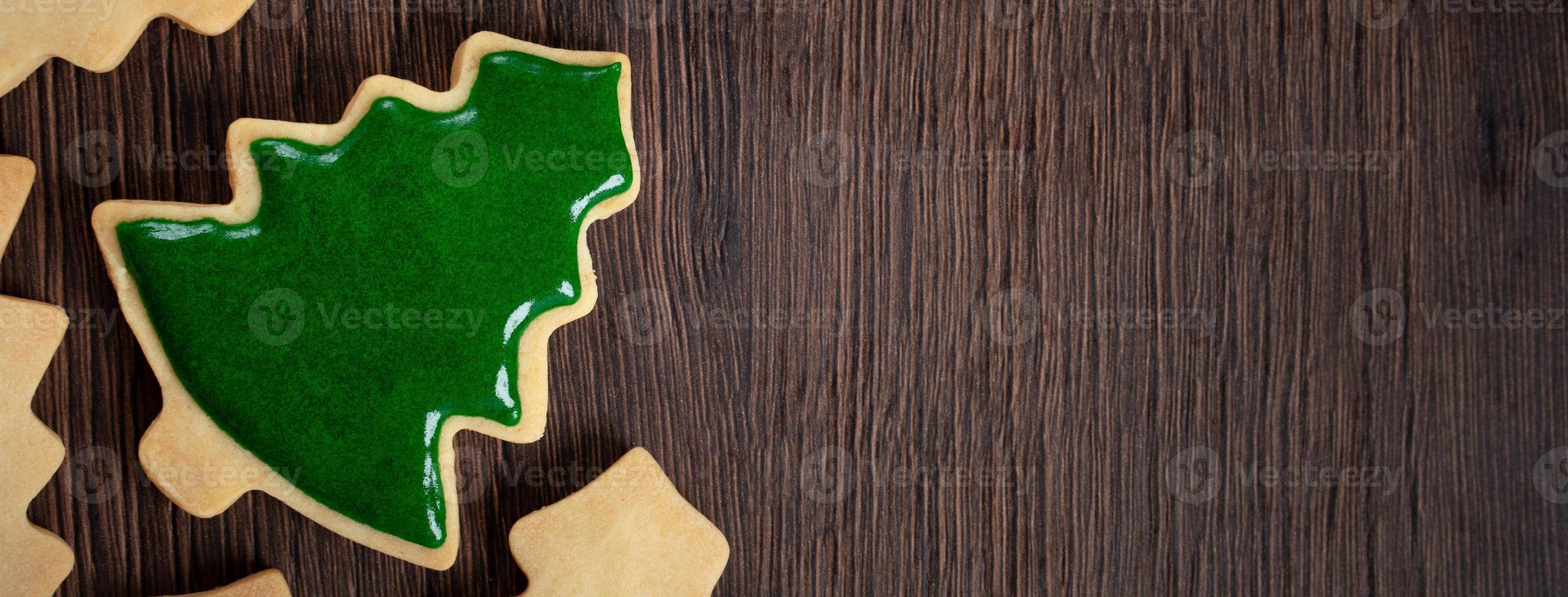 Top view of decorated Christmas tree cookie on wooden table background with copy space. photo