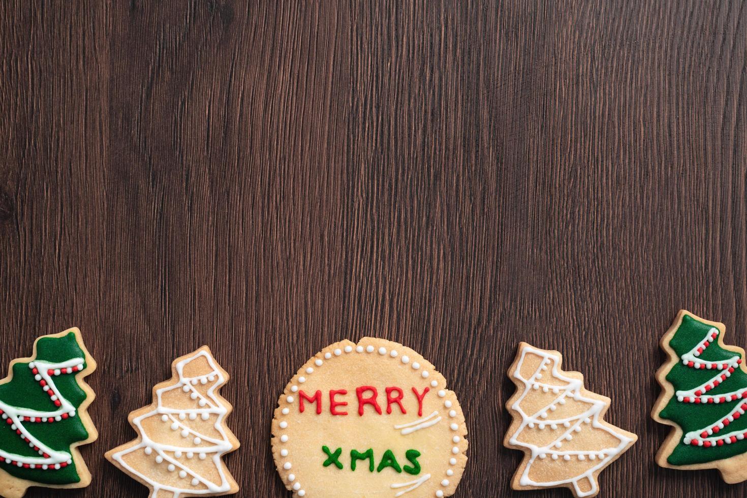 Top view of decorated Christmas tree cookie on wooden table background with copy space. photo