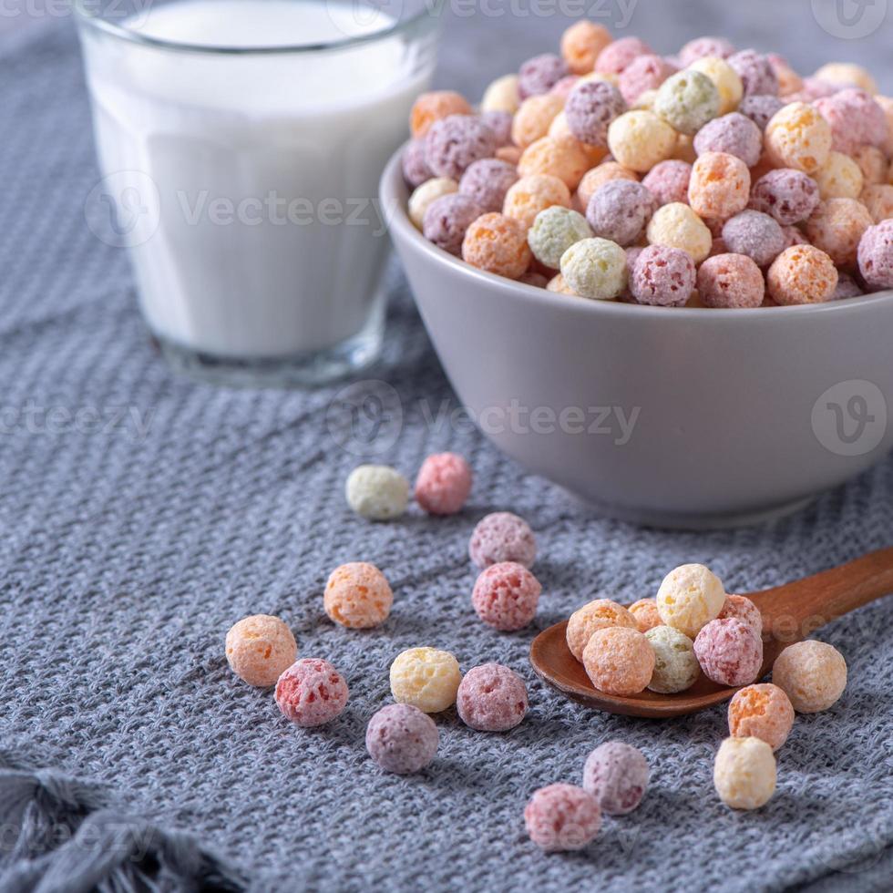 Colorful cereal corn balls mix sweets in a bowl on gray cement background. photo