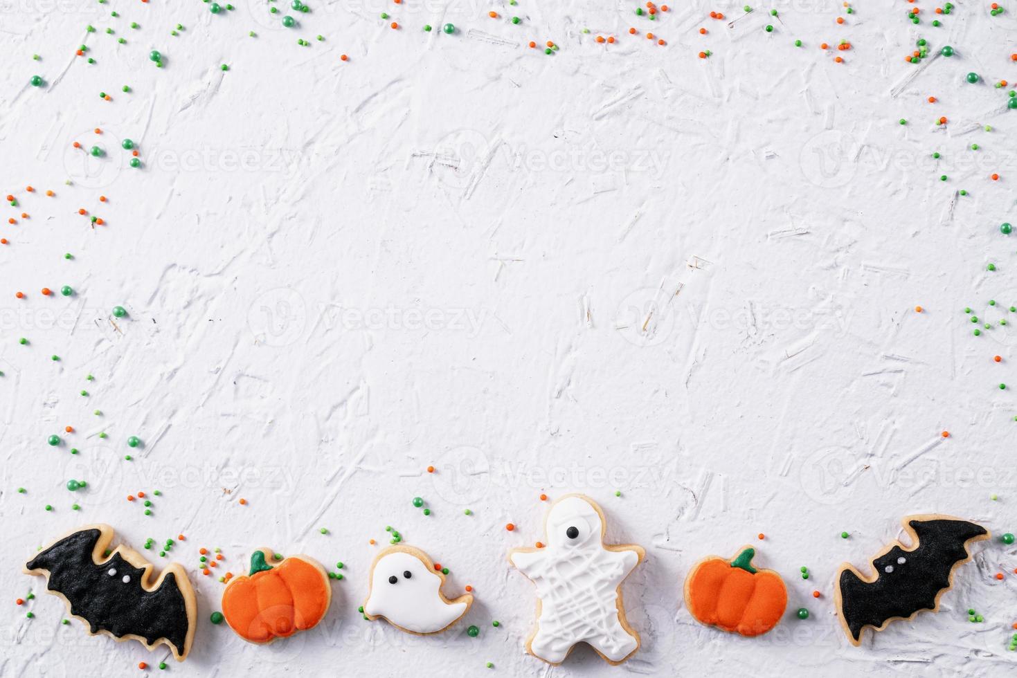 Top view of Halloween festive decorated icing sugar cookies on white background. photo