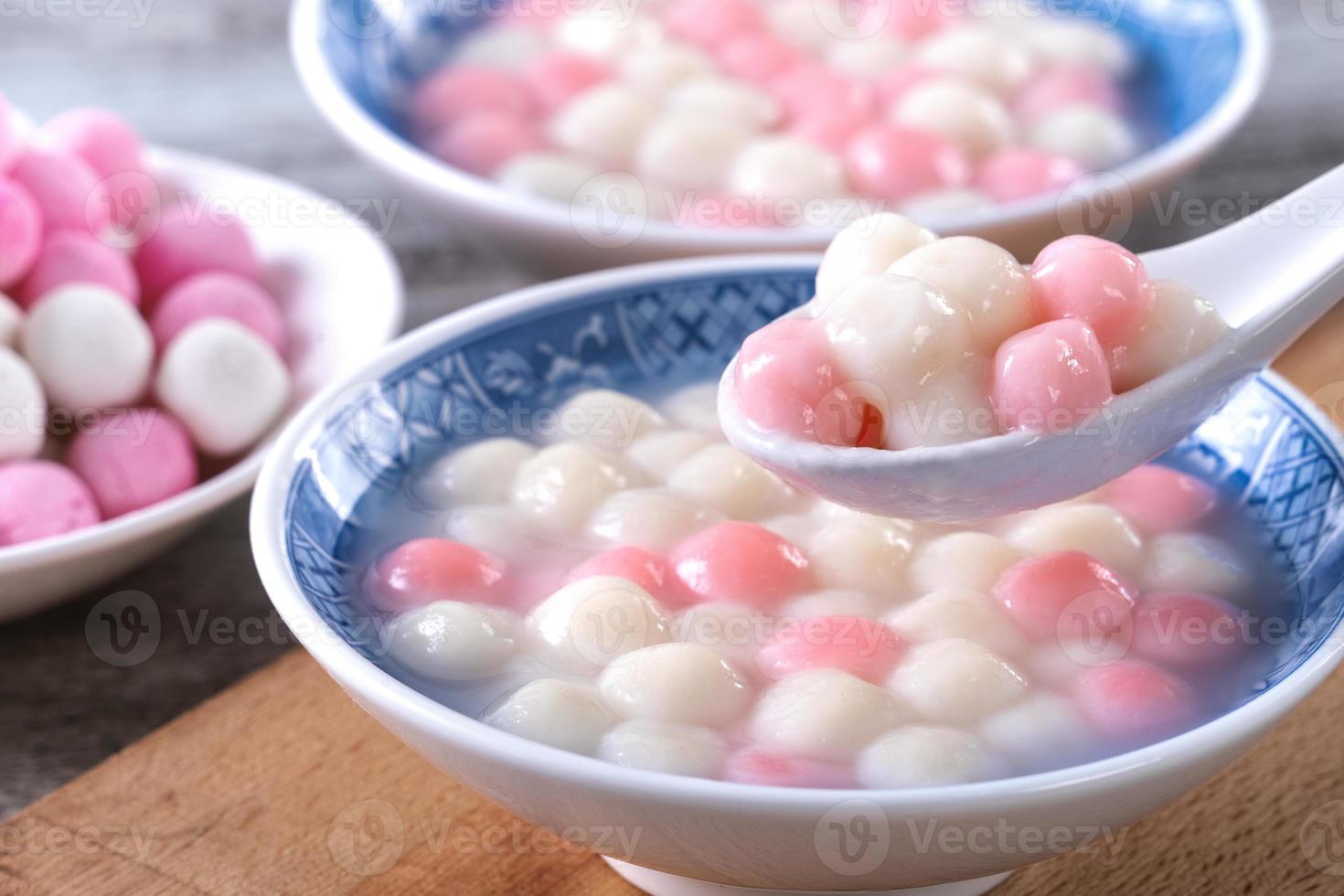 Close up of red and white tangyuan in blue bowl on wooden background for Winter solstice. photo