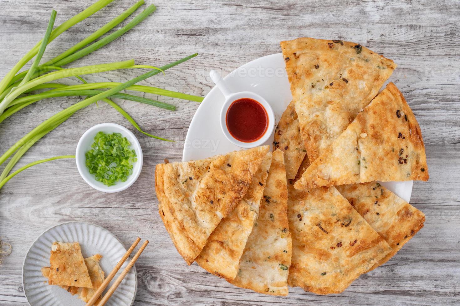 Delicioso panqueque de cebolleta taiwanés sobre fondo de mesa de madera foto