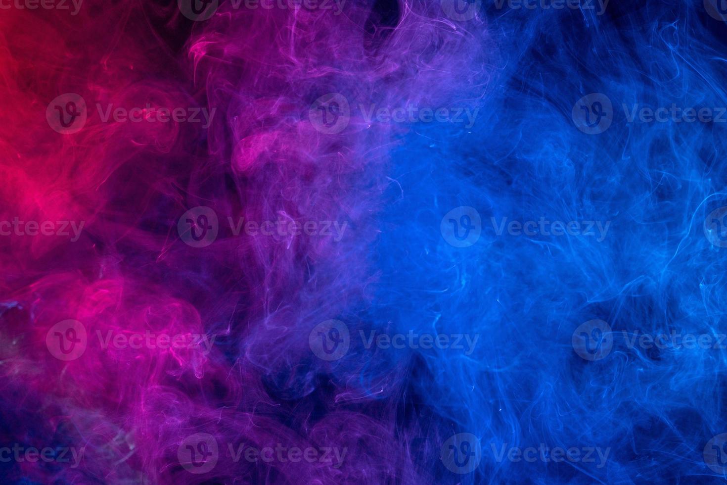 Conceptual image of colorful red and blue color smoke on dark black background. photo