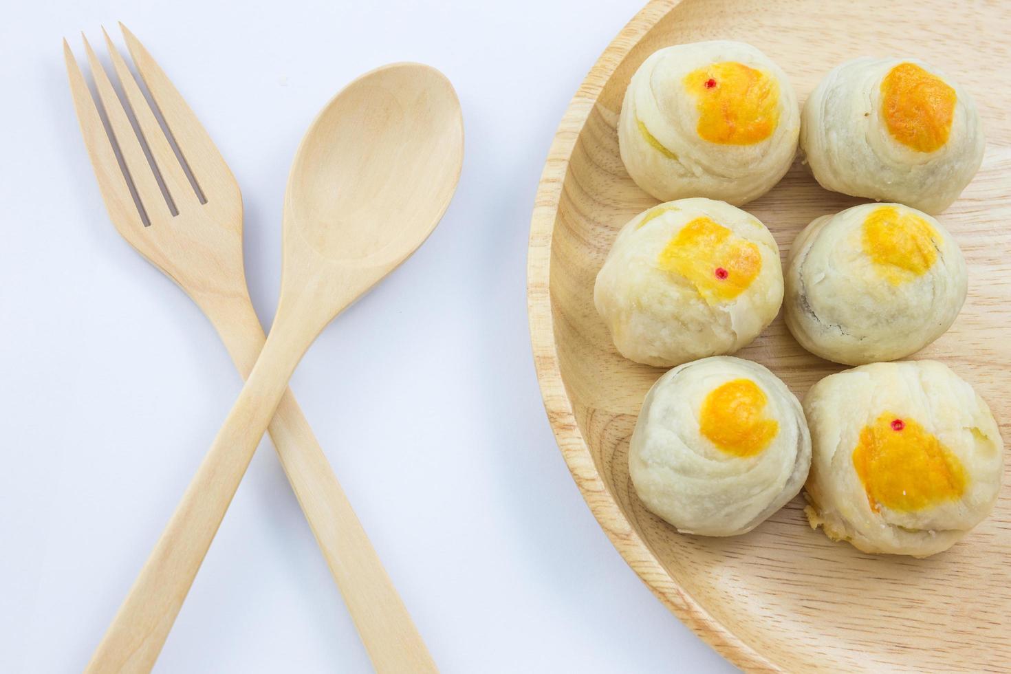 Chinese Pastry Mung Bean or Mooncake with Egg Yolk on wooden dish and spoon fork photo