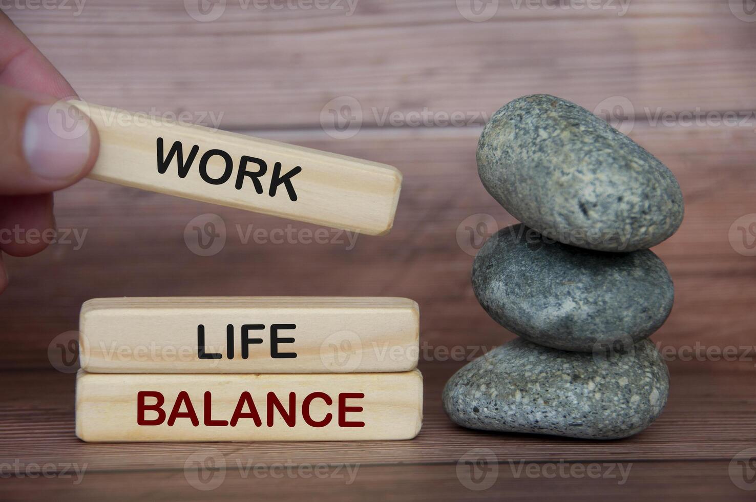 Work life balance text on wooden blocks with rocks and wooden cover background. photo