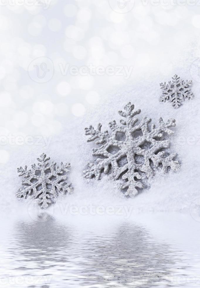 Glass toy snowflake on snow background. photo