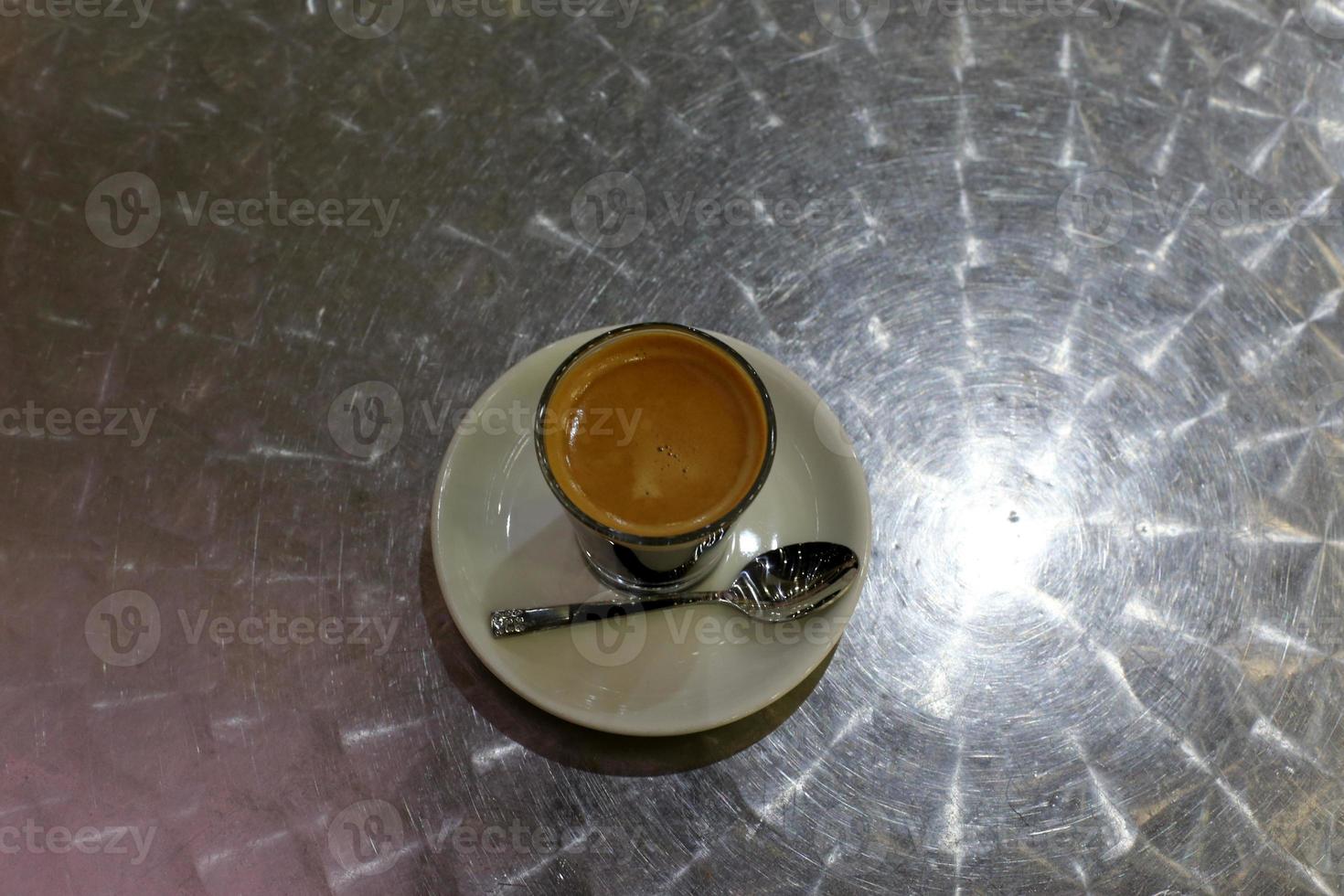 Hot and strong coffee is poured into a cup. photo